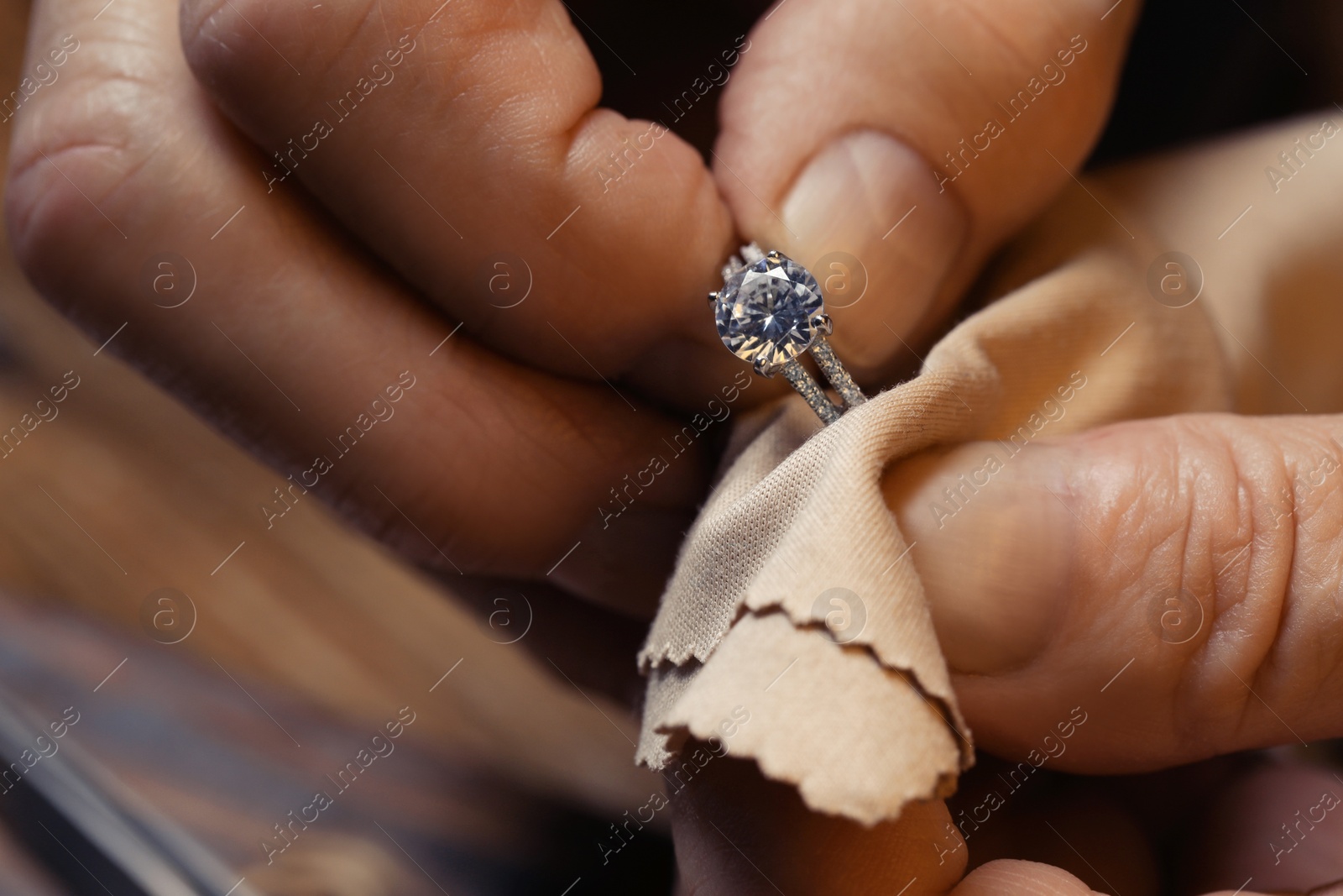 Photo of Professional jeweler working with ring, closeup view