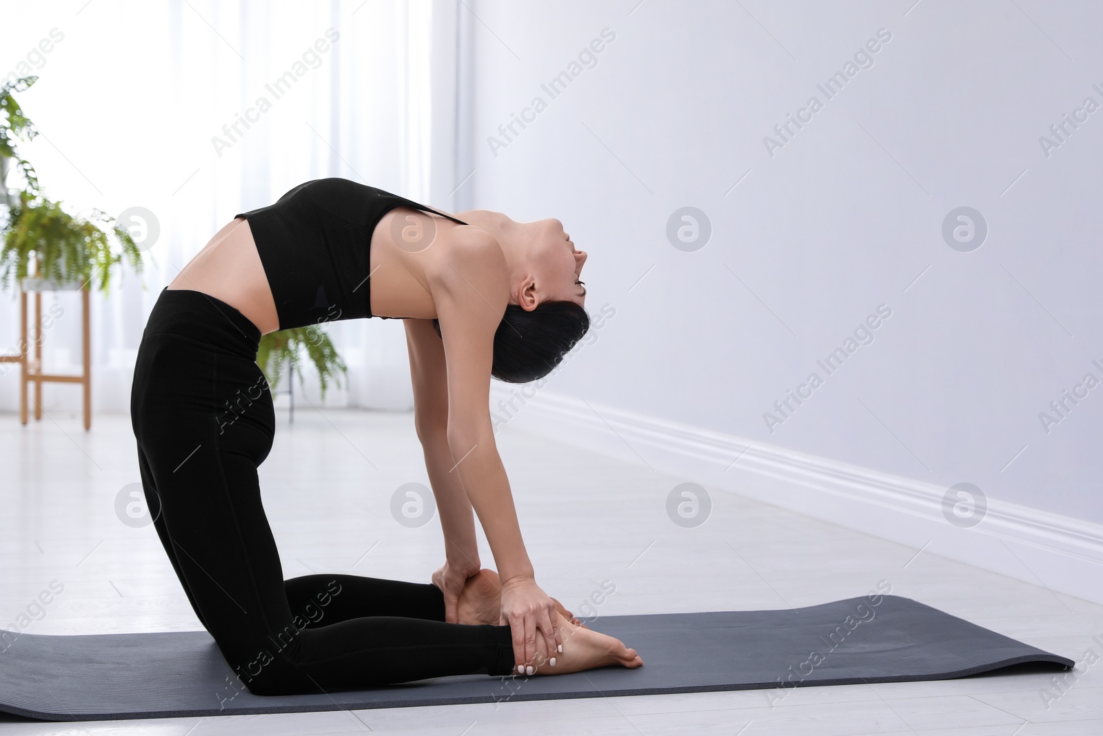 Photo of Professional young acrobat practicing yoga at home