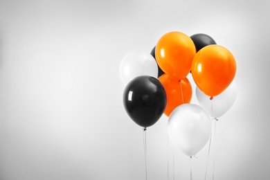 Colorful balloons on light background, space for text. Halloween party