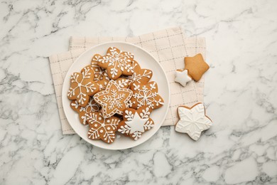 Tasty star shaped Christmas cookies with icing on white marble table, top view