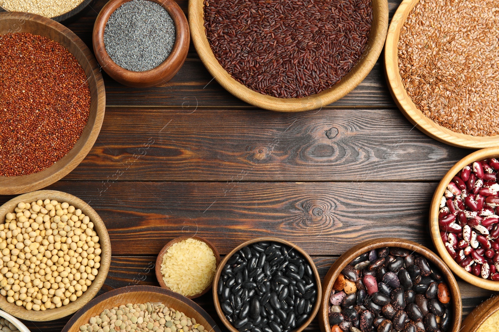 Photo of Frame of different grains and seeds on wooden table, flat lay with space for text. Veggie diet