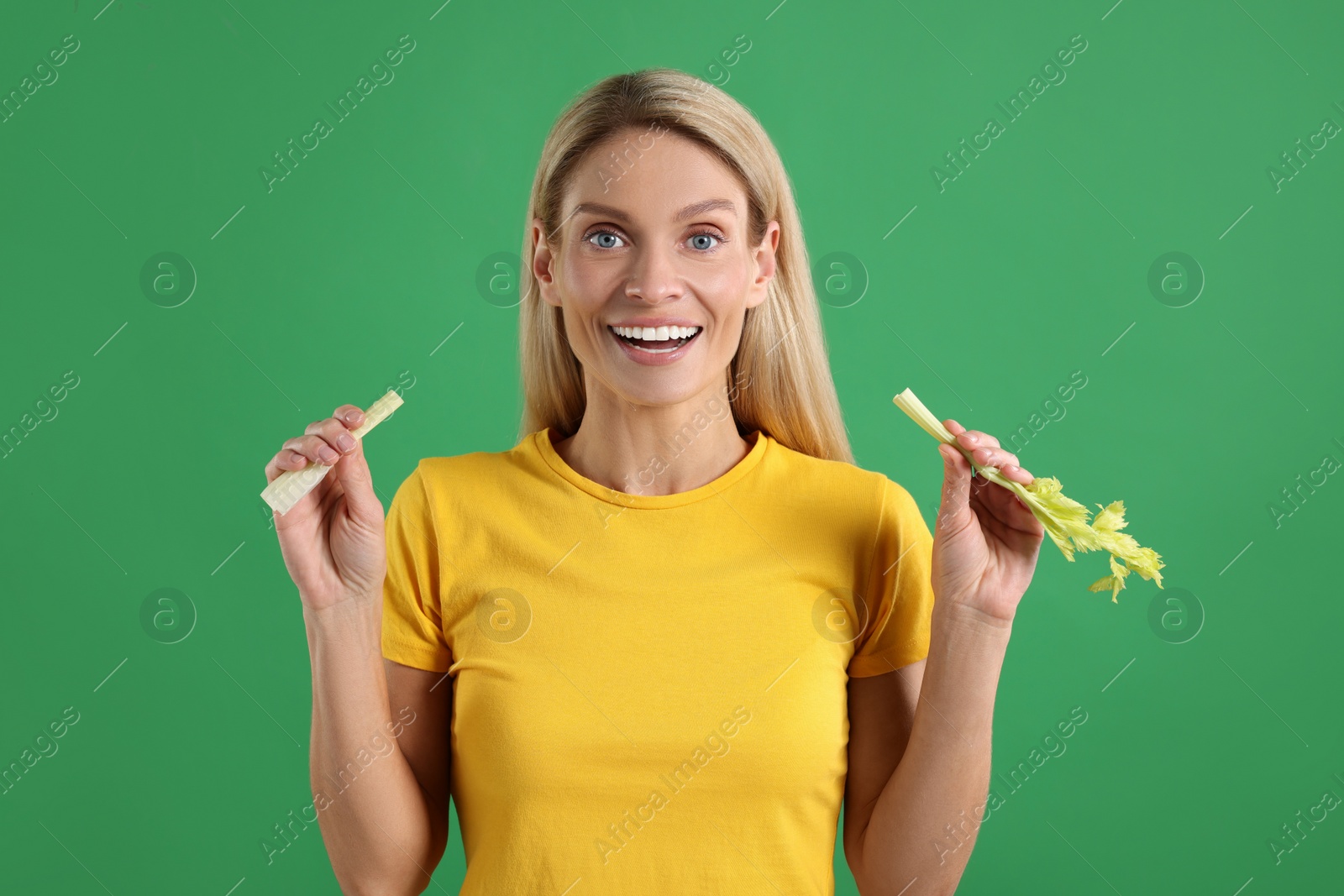 Photo of Woman with pieces of fresh celery stem on green background