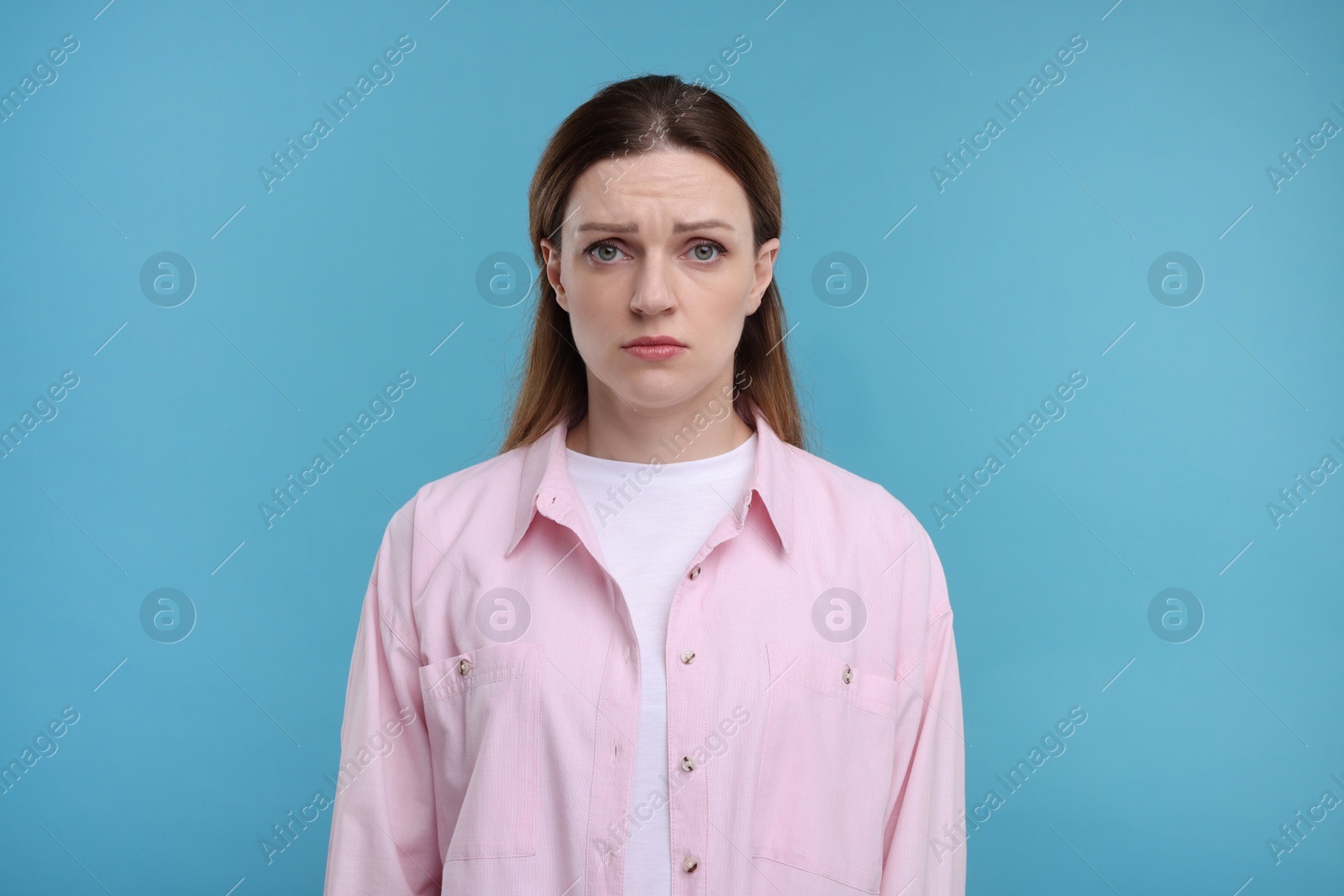 Photo of Portrait of sad woman on light blue background