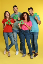 Photo of Group of people with recycling symbols on yellow background
