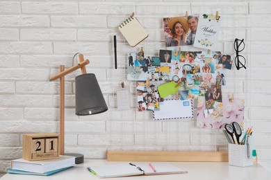 Photo of Stylish workplace with stationery and vision board