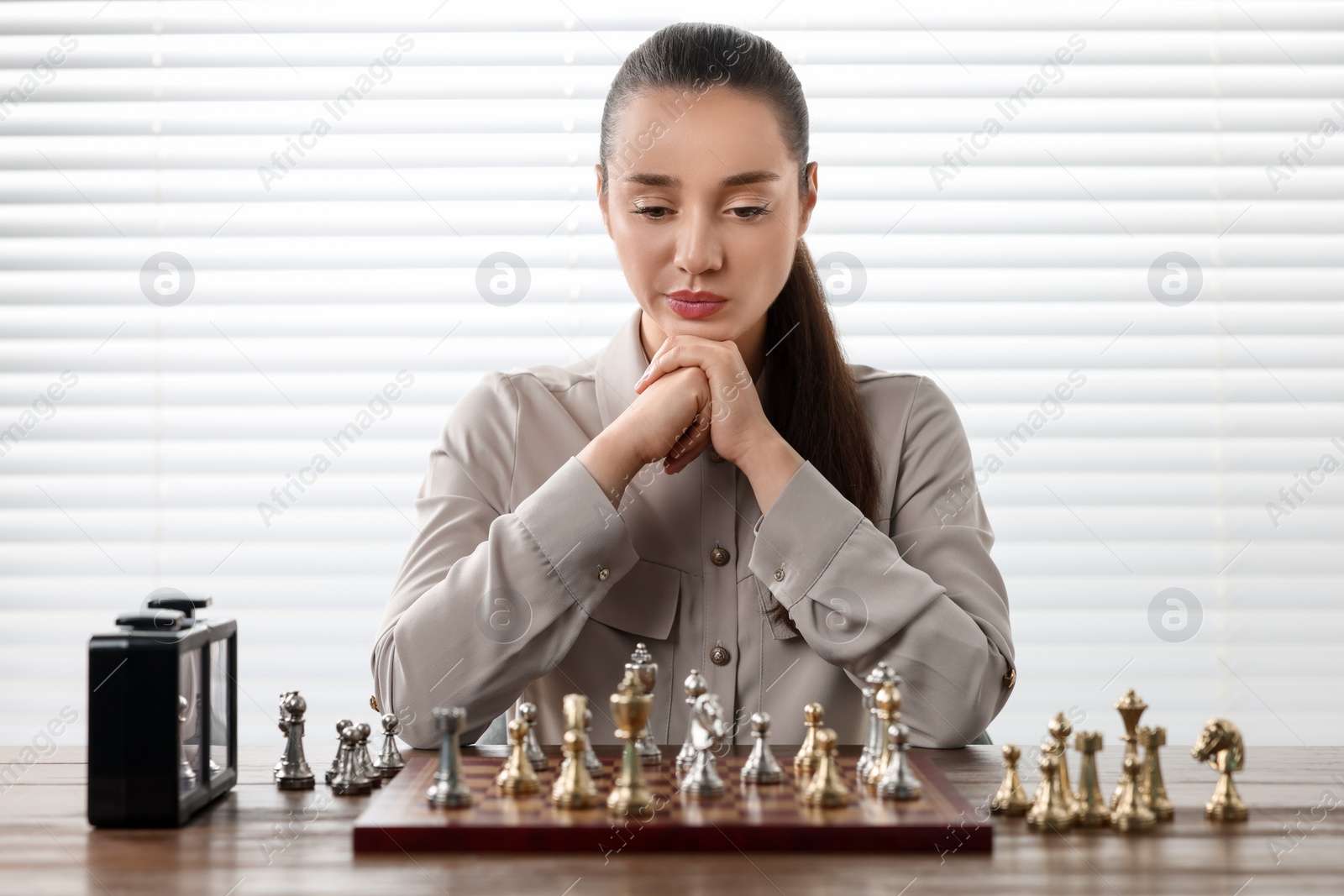 Photo of Woman playing chess during tournament at table indoors