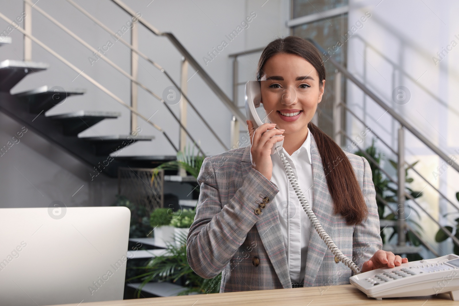 Photo of Female receptionist talking on phone at workplace