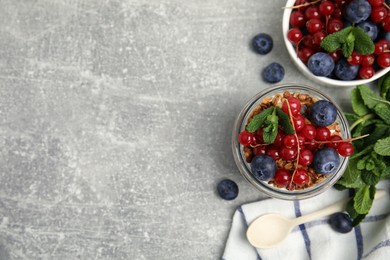 Photo of Delicious yogurt parfait with fresh berries and mint on light grey table, flat lay. Space for text