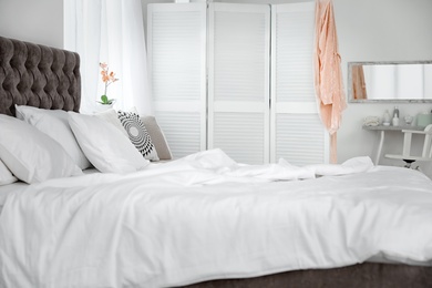 Photo of Bed with soft pillows in elegant room interior