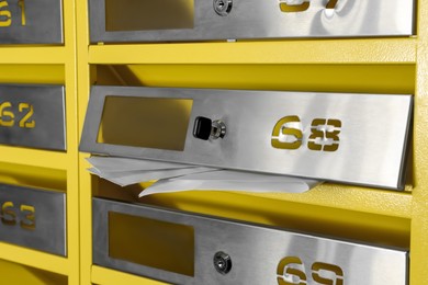 Photo of Metal mailboxes with keyholes, numbers and receipts, closeup