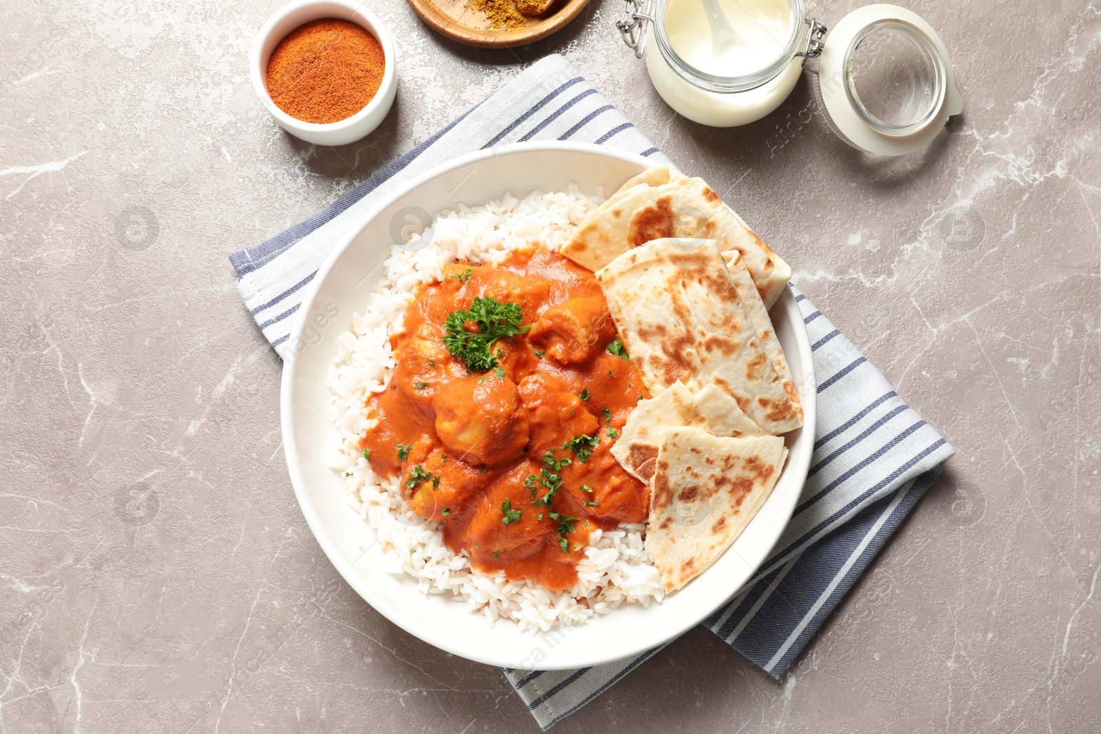 Photo of Delicious butter chicken with rice served on table, flat lay