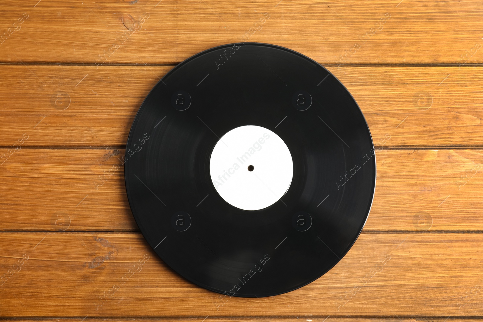 Photo of Vintage vinyl record on wooden table, top view