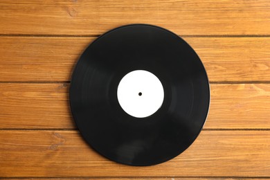 Photo of Vintage vinyl record on wooden table, top view