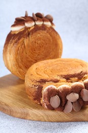 Photo of Supreme croissants with chocolate chips and cream on grey table, closeup. Tasty puff pastry