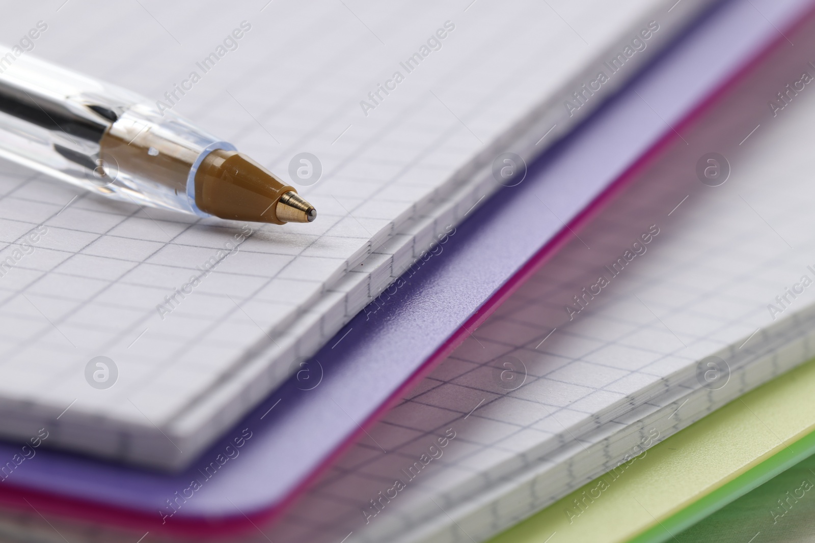 Photo of Ballpoint pen and colorful notebooks, closeup view