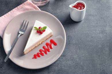 Photo of Delicious cheesecake served with sweet jam on plate