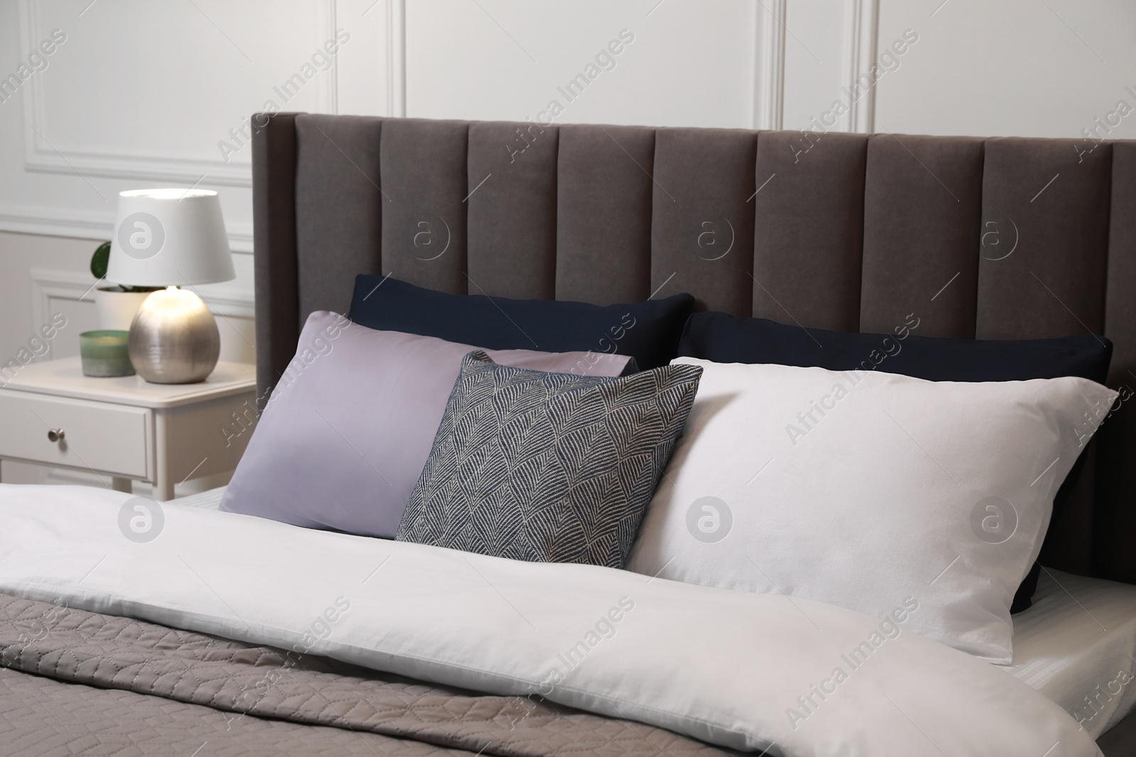 Photo of Comfortable bed with pillows and bedding in stylish room. Interior design