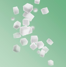 Image of Refined sugar cubes in air on green background