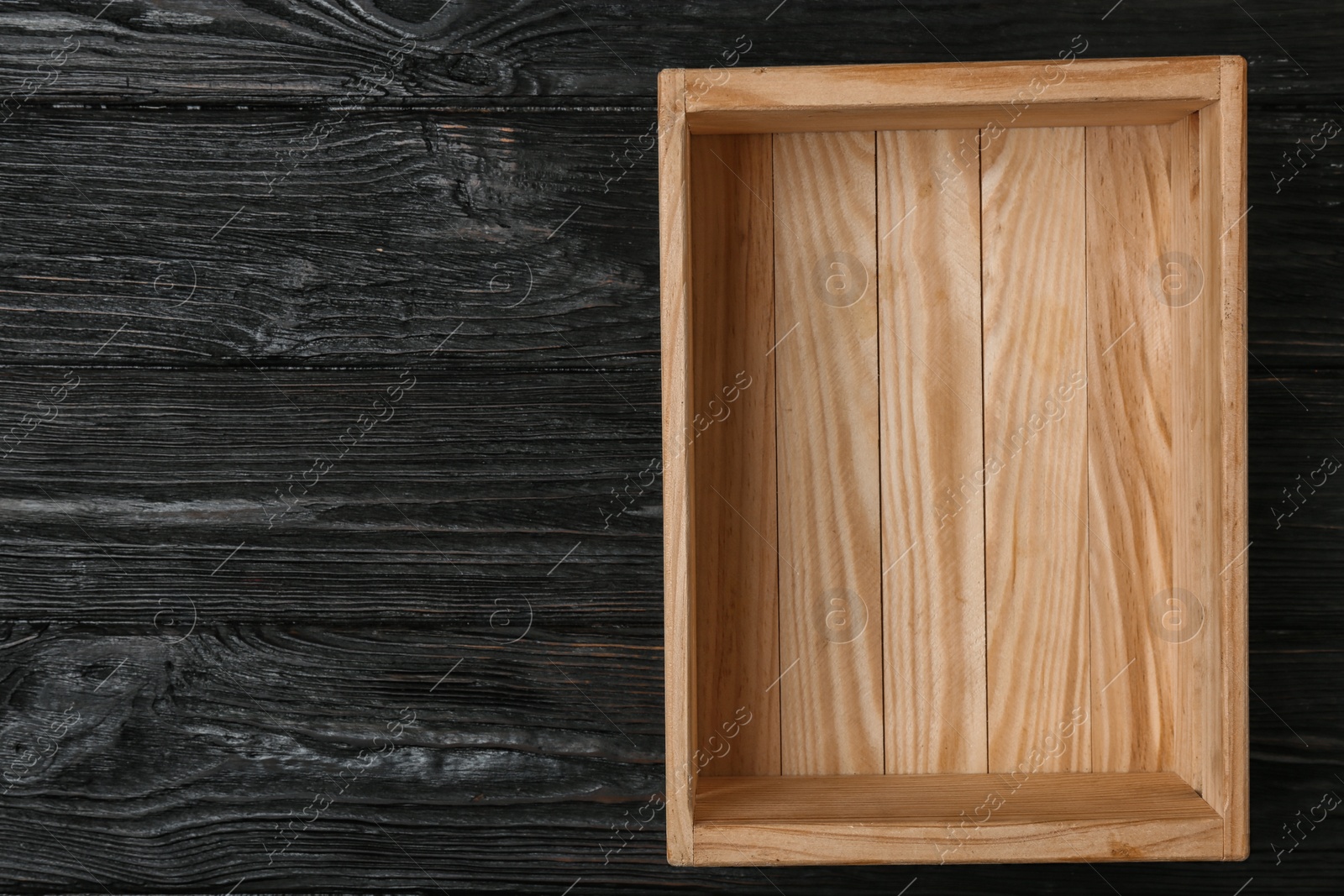 Photo of Empty wooden crate on dark background, top view with space for text