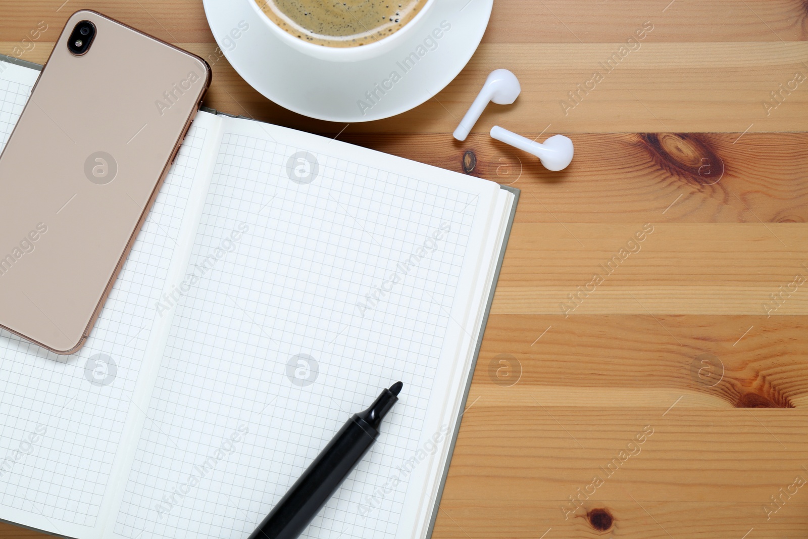 Photo of Empty notebook, coffee, smartphone and stationery on wooden table, flat lay. Space for text