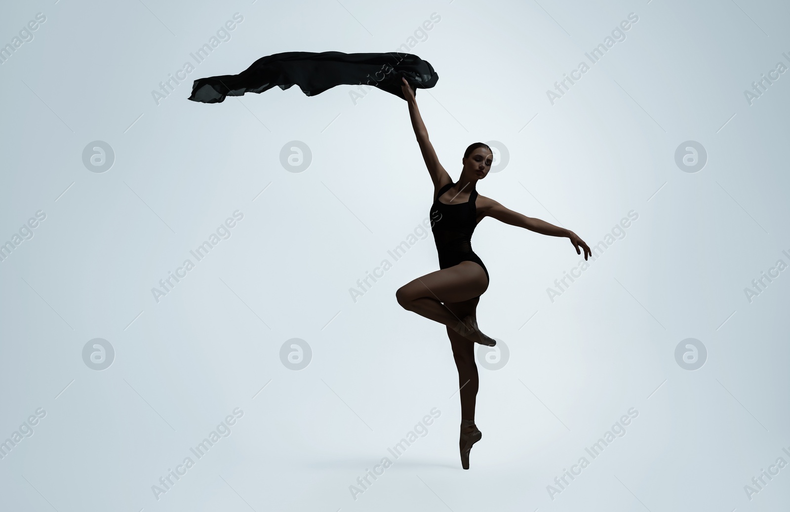 Image of Beautiful ballerina with black veil dancing on light background, space for text. Dark silhouette of dancer