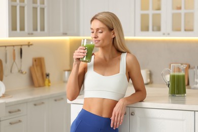 Photo of Woman drinking fresh celery juice in kitchen