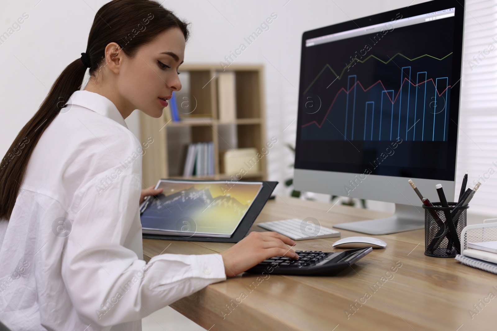 Photo of Businesswoman working at table in office. Forex trading