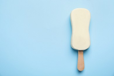 Photo of Ice cream with glaze on light blue background, top view. Space for text