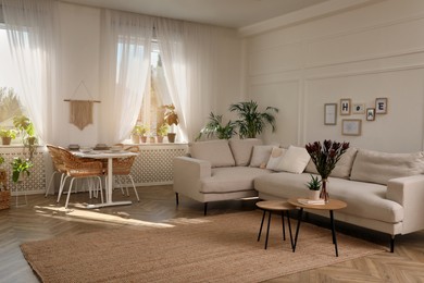 Stylish room interior with comfortable sofa and beautiful houseplants