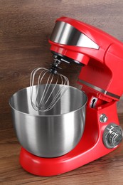 Photo of Modern red stand mixer on wooden table