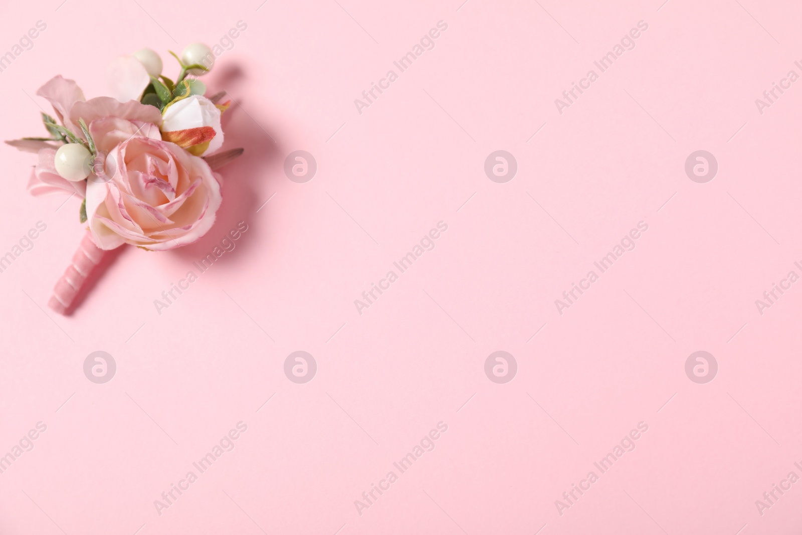 Photo of Stylish boutonniere on pink background, top view. Space for text