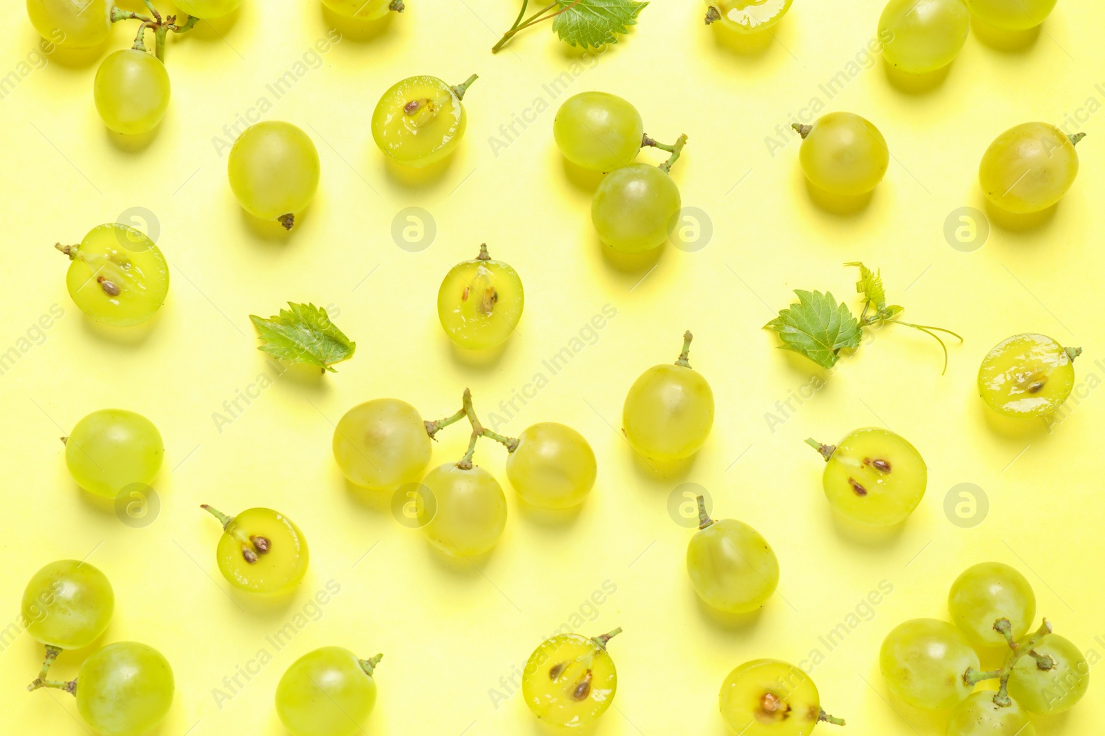 Photo of Flat lay composition with fresh ripe juicy grapes on yellow background