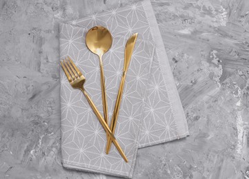 Photo of Beautiful cutlery set and kitchen towel on grey table, top view