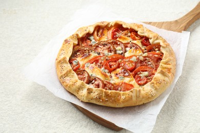 Photo of Tasty galette with tomato and cheese (Caprese galette) on light textured table, closeup