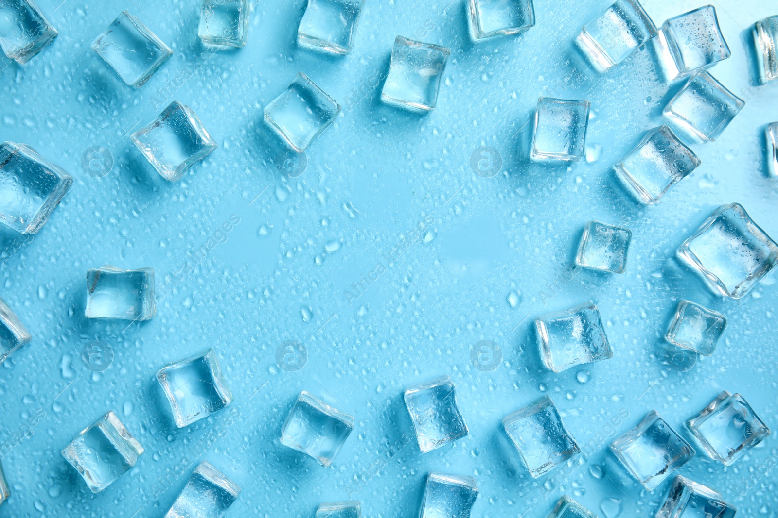 Photo of Frame made of ice cubes with space for text on turquoise background, flat lay. Refreshing drink ingredient