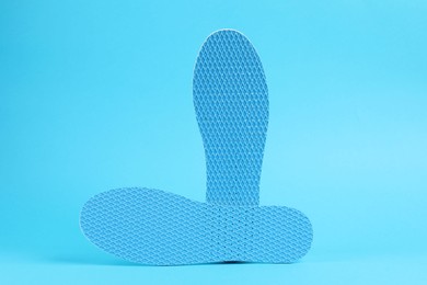 Photo of Pair of shoe insoles on light blue background