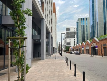 Photo of City street with beautiful buildings under cloudy sky, low angle view