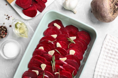 Flat lay composition with raw beetroot slices on light marble table