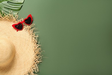 Photo of Straw hat, sunglasses, leaf and space for text on green background, flat lay. Stylish headdress