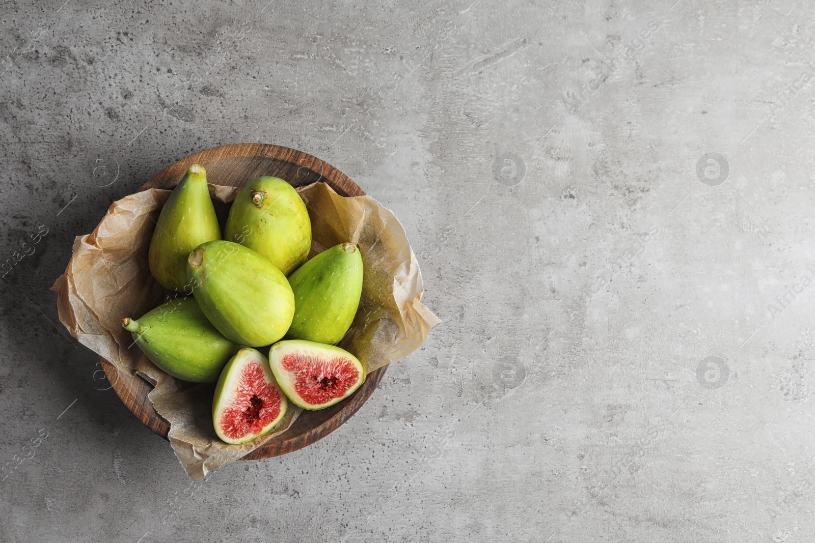 Photo of Bowl with fresh ripe figs on gray background, top view