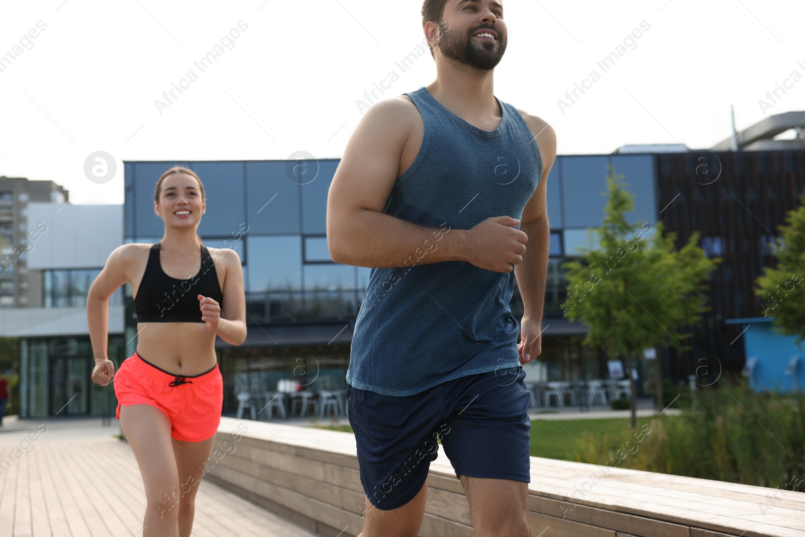 Photo of Healthy lifestyle. Happy couple running outdoors on sunny day