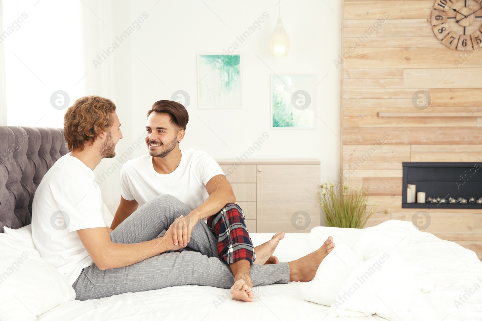 Photo of Happy gay couple on bed at home