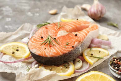 Fresh raw salmon steak with lemon on table, closeup