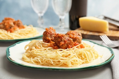 Delicious pasta with meatballs and tomato sauce on table