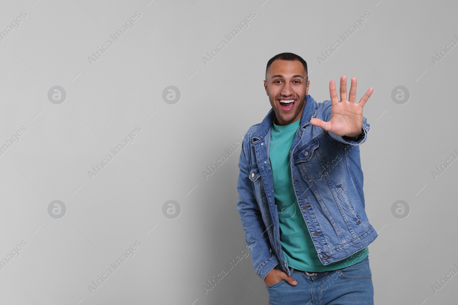 Photo of Man giving high five on grey background. Space for text