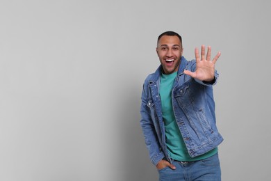 Photo of Man giving high five on grey background. Space for text