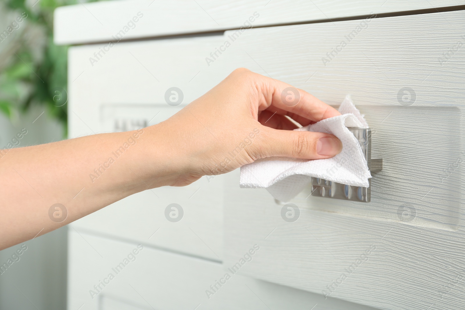 Photo of Woman using tissue paper to open drawer, closeup