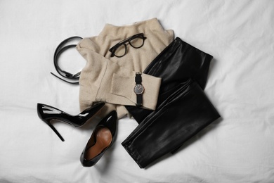 Photo of Stylish look with cashmere sweater, flat lay. Women's clothes and accessories on fabric