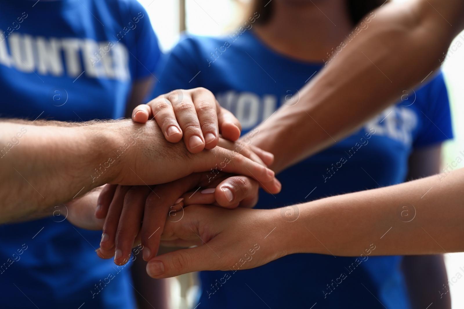 Photo of Group of volunteers joining hands together, closeup