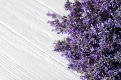 Beautiful fresh lavender bouquet on white wooden table, closeup. Space for text